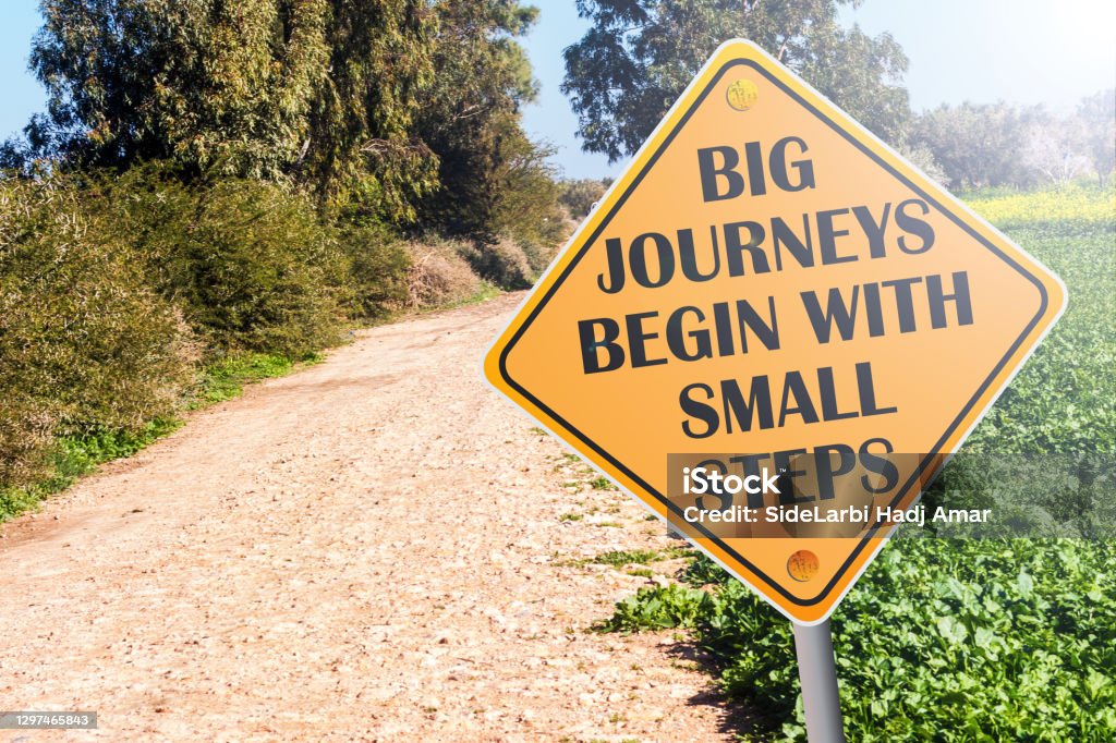 Big Journeys Begin With Small Steps sign on road Journey Stock Photo