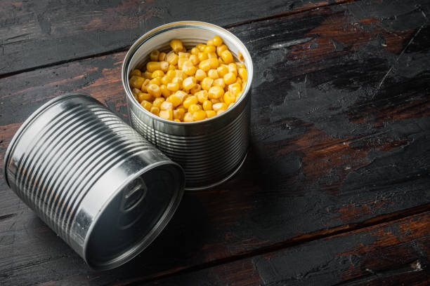 istock Canned corn, on old dark  wooden table background with copy space for text 1297465853