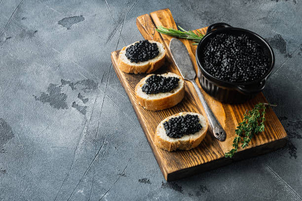 istock Canapes with black sturgeon caviar, on gray background  with copy space for text 1297466133