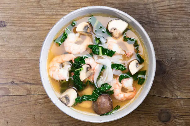 Asian soup bowl with ricenoodles, kale, prawns and mushrooms