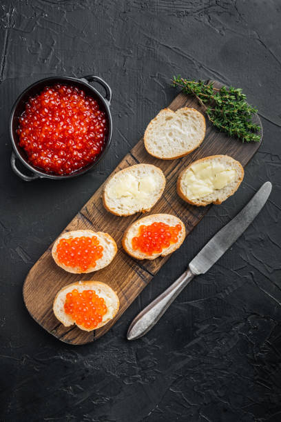 istock Canape with Red Salmon Caviar for New Year, on black background, top view flat lay 1297467340