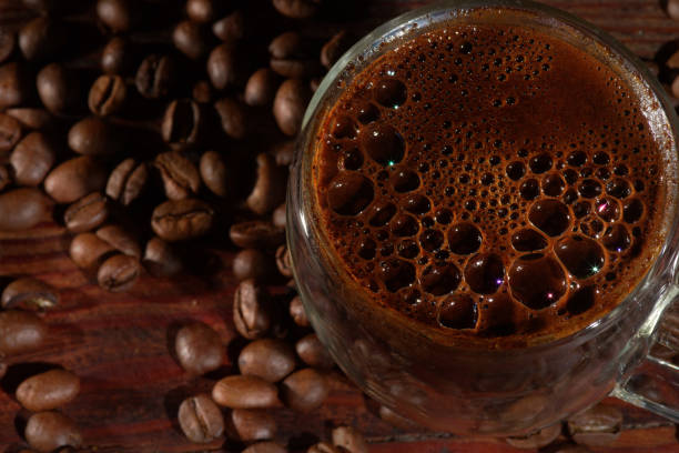 istock Hot black coffee and coffee beans  on the old wooden table 1297467964