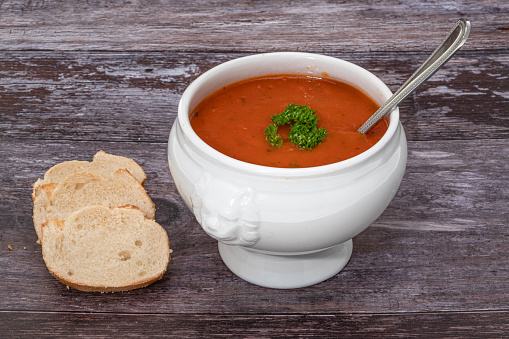 Bowl of thick tomato soup with crusty bread