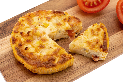 Cheese frittata served on a wooden cutting board - white background