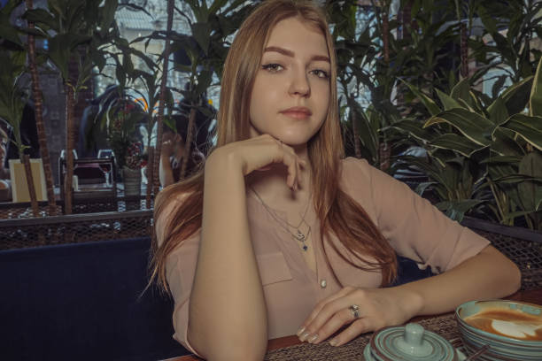 istock Heartbroken lady sitting in cafeteria. She is looking sad and melancholic. Angle view. 1297470504