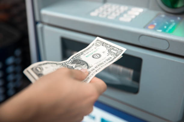 istock Woman withdrawing money from ATM 1297472553