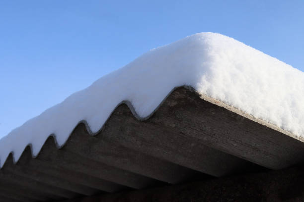 istock Fresh snow covered the roof with a thick layer against the blue sky, winter background 1297473809