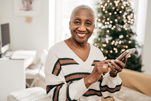 Senior women using smart home app on her cellphone