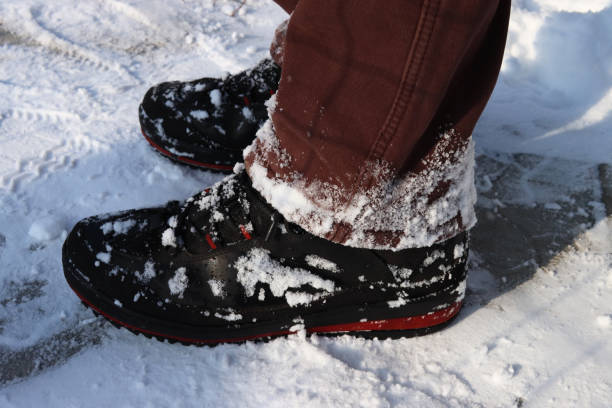 istock Human feet in boots standing in the snow 1297473899