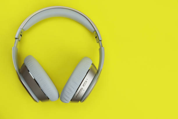 istock wireless technologies. Full-size headphones on a yellow background 1297474847