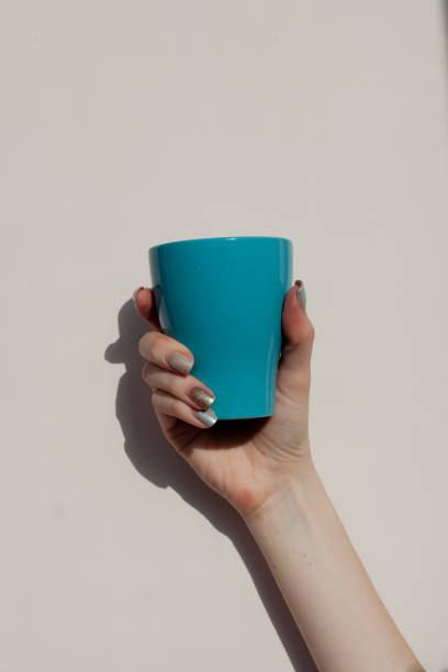 istock A woman's hand holds a Cup on a white background 1297475212