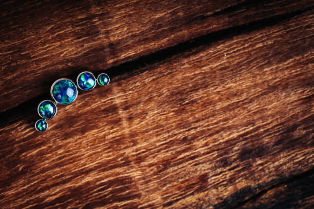 Beautiful piercing jewelry on wooden background. Macro shot. Selective focus.