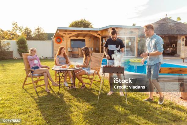 Friends Grilling Meat And Having Fun At Backyard Poolside Barbecue Party Stock Photo - Download Image Now