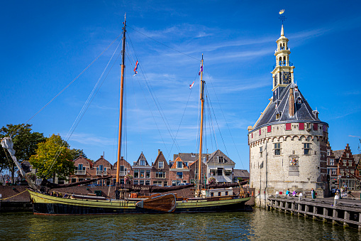 Ships and Hoofdtoren, a historical defense tower / harbor control tower located in the harbor of Hoorn, North Holland, Netherlands