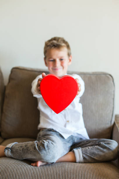 istock Cute boy holding in hands heart shaped gift box for Valentines day 1297479738