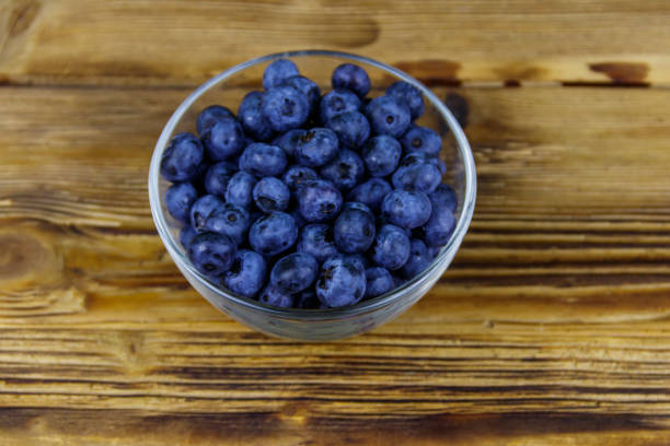 istock Fresh blueberry in glass bowl on a wooden table 1297480659