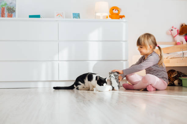 istock Little Girl Feeds A Cat With Milk. 1297481206
