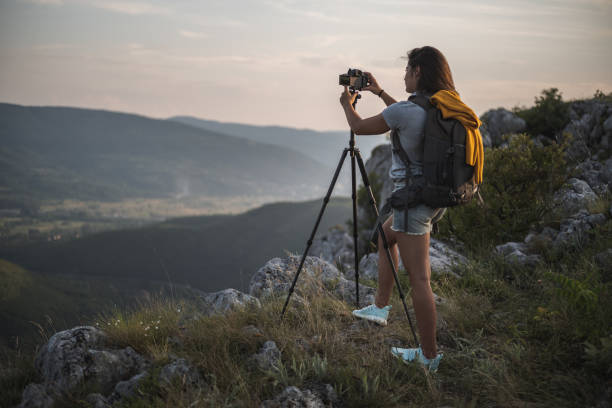 istock Woman standing in nature and taking a picture 1297481987
