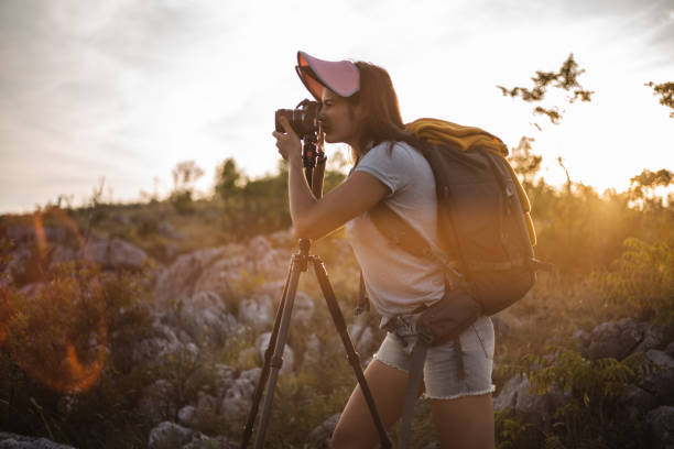 istock Woman standing in nature and taking a picture 1297482064
