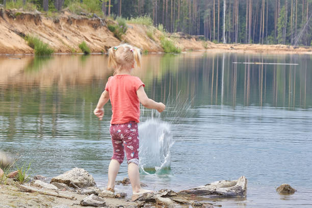 istock A girl throws a stone into a lake 1297482401