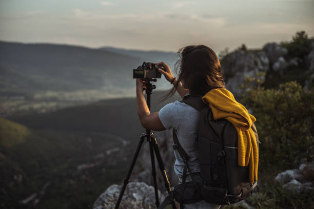 istock Woman standing in nature and taking a picture 1297482472