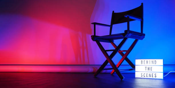 istock Behind the scenes letterboard text on Lightbox or Cinema Light box. Movie clapperboard megaphone and director chair beside. Background LED color change loop. static camera in video production studio. 1297483182