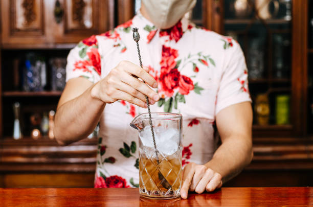 istock Barman pouring whiskey wearing protective mask on the bar counter 1297483663