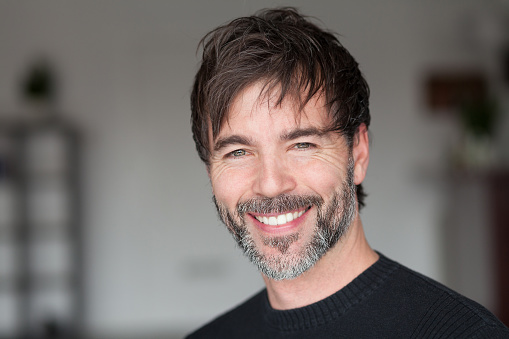 Elderly man smiling at the camera. Styling hair. Handsome man.