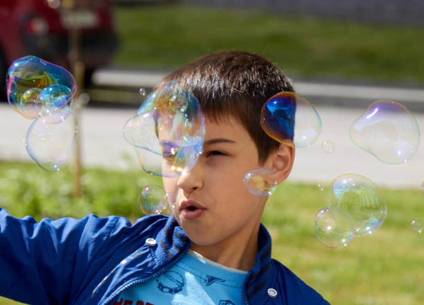 istock boy blowing bubbles in the summer sun joy 1297484925
