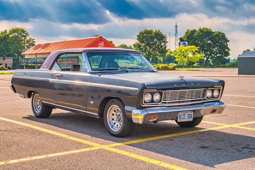 1965 Ford Fairlane 500 car is parked in a parking lot in Brantford, Ontario, Canada on a sunny day.