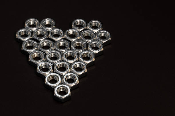 istock Heart shape made of hex bolts on dark grey background. 1297486710