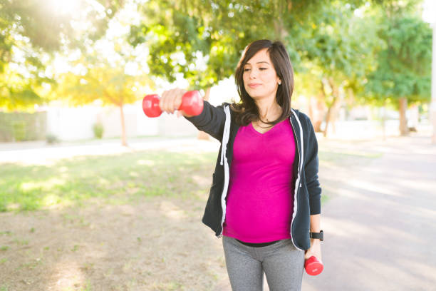 istock Happy pregnant woman using weights for her workout 1297486849