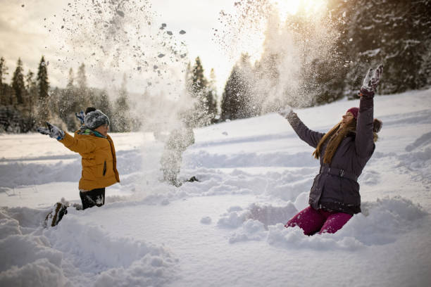 istock Kids throwing up the snow on the forest meadow. 1297489077