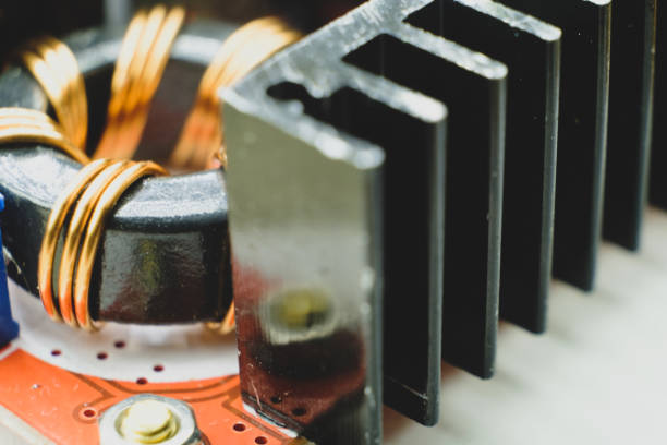 istock Induction coil macro photo. Ferrite base wrapped with copper wire with heather on foreground 1297489363