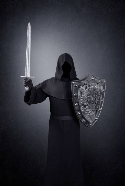 istock Ghostly figure with medieval sword and shield in the dark 1297491724