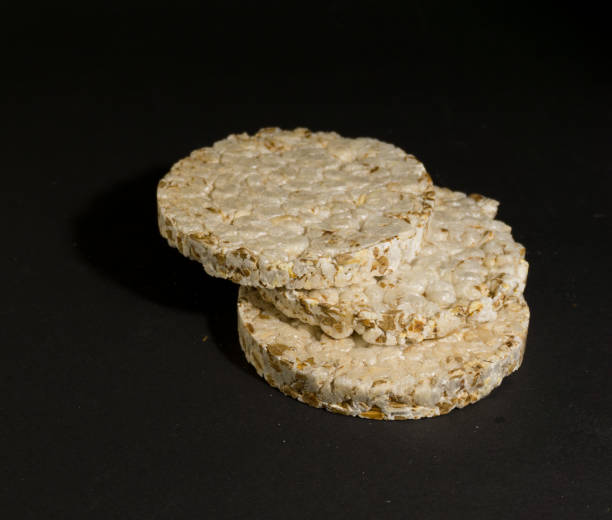 istock Grain crispbreads crispy rice and diet bread. Stack of puffed whole grain crispbread. Rice cake puffed rice on black background 1297491927