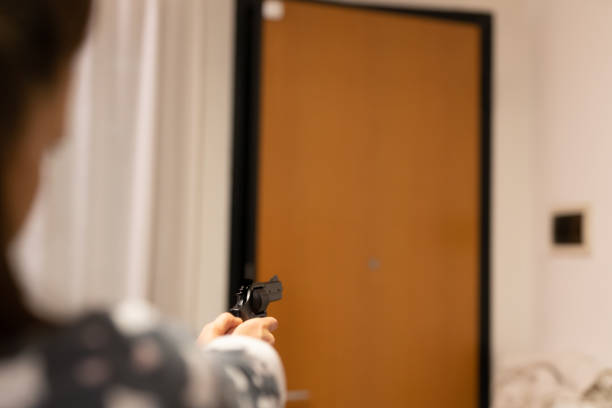 istock Girl with a handgun defending from robber 1297492589