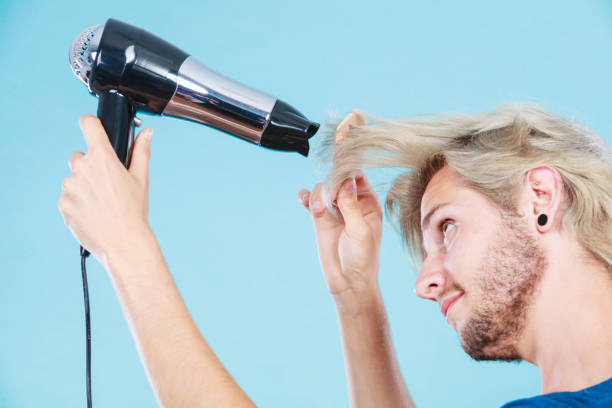 istock Trendy man with hair dryer 1297493577