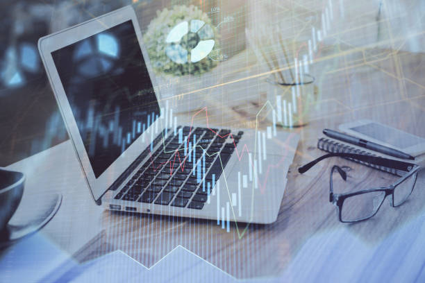 istock Stock market graph on background with desk and personal computer. Multi exposure. Concept of financial analysis. 1297495948