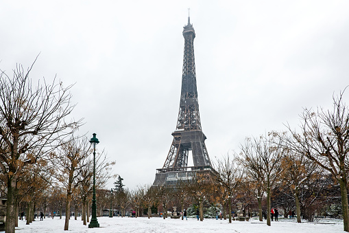View to the Eiffel Tower with snow. Unusual weather conditions in Paris. Champ de Mars in Paris, France, January 16, 2021.