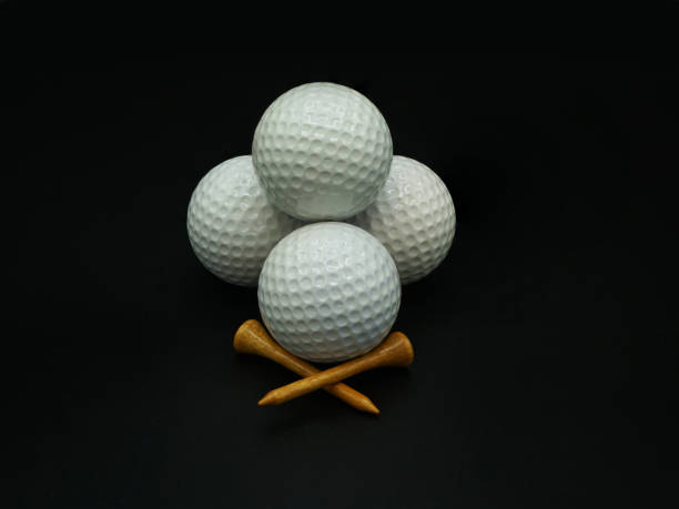 istock Stacked golf balls and tees on black background 1297498198