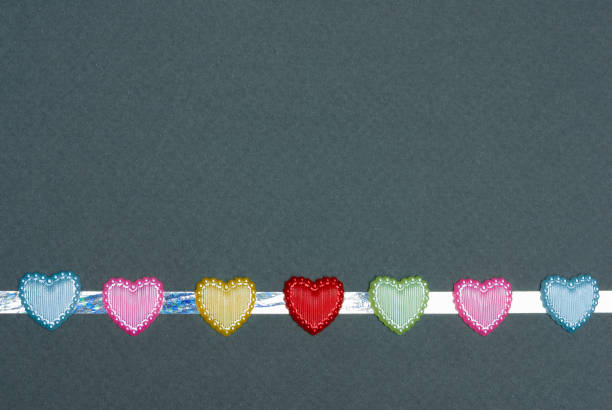 istock Ribbon of multicolored hearts on gray background 1297500146