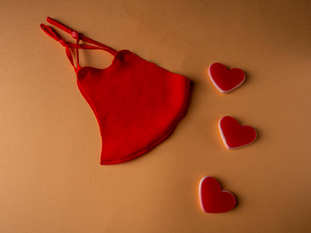 istock Red mask which is located next to three white and red hearts 1297500222