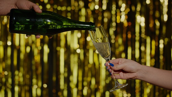 A woman filling champagne flutes.