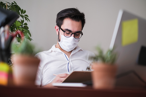 Young man working at office in the pandemic