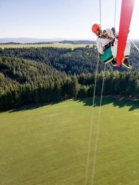 istock Epic view on Industrial climber,  rope access technician working on tip of the wind turbine blade and is extremely high up above country side 1297501564