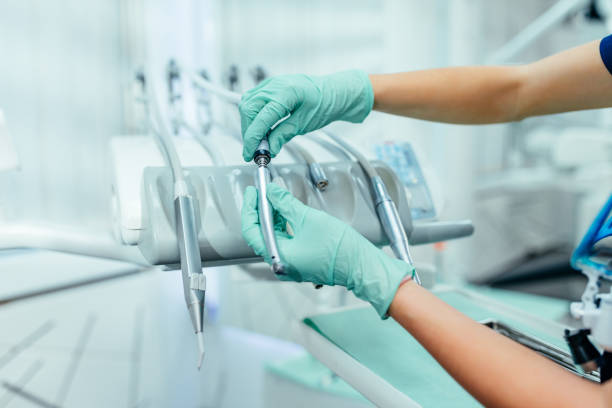 mains de dentiste nettoyant des outils dentaires - dental assistent photos et images de collection