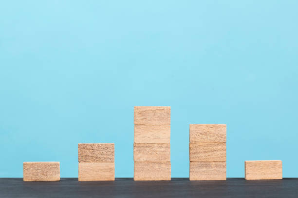 istock Wooden block stacking as step stair  on blue background 1297503327