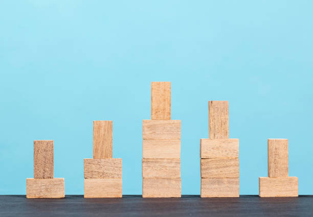 istock Wooden block stacking as step stair  on blue background 1297503471