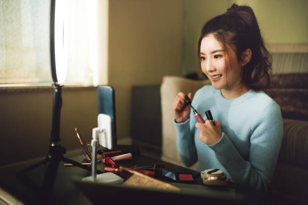 Young cheerful Asian woman doing live streaming for social media and Internet Young cheerful Asian woman doing live streaming for social media and Internet. live broadcast photos stock pictures, royalty-free photos & images